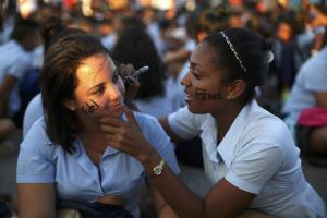Mourners paint each other's faces as they gather to pay tribute to Cuba's late President Fidel Castro at Revolution Square in Havana, Cuba, November 29, 2016. REUTERS/Edgard Garrido